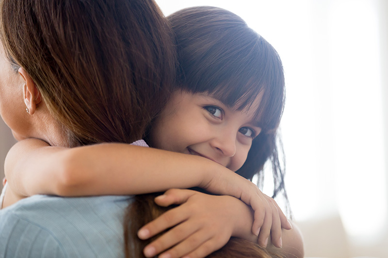 A child hugging an adult at preschool