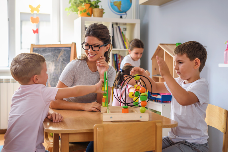 A teacher and children playing with educational toys